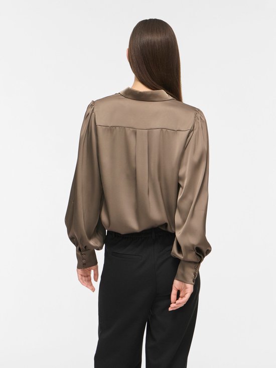 Achterkant taupe satijnen blouse met pofmouwen.