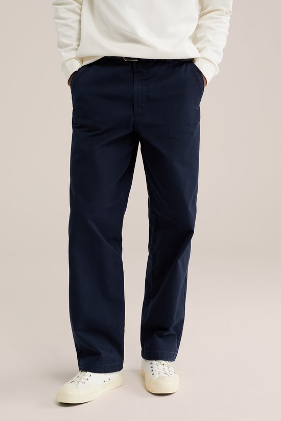 Donkerblauwe chino met een rechte pasvorm, gedragen door een model. De voorkant van de broek is zichtbaar.