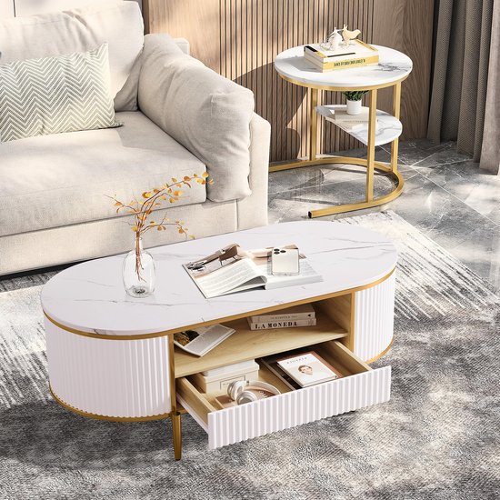Ovale salontafel met marmerlook blad, wit geribbeld design en gouden poten. Met open vakken en een lade.