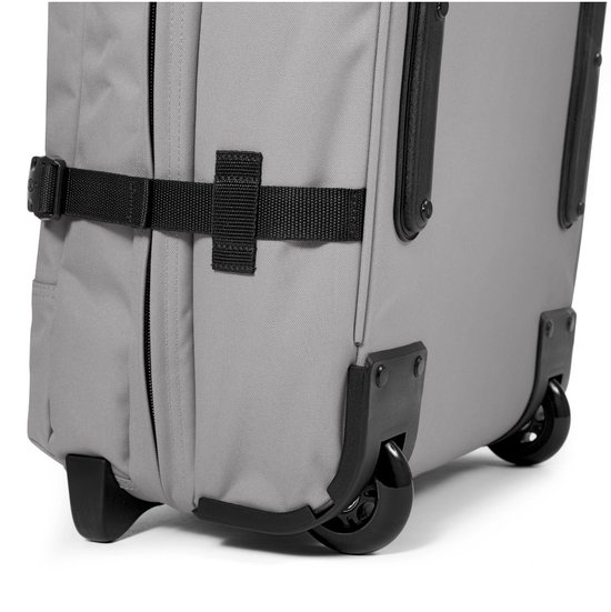 Grijze Eastpak Tranverz L reiskoffer met zwarte wielen en riemen.