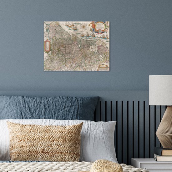 Carte historique des Pays-Bas accrochée à un mur au-dessus d'un lit.