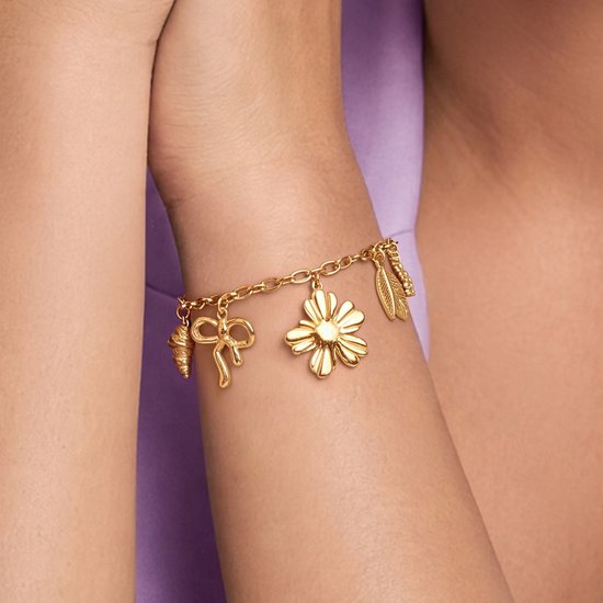 Gouden bedelarmband met strik, bloem en veer.