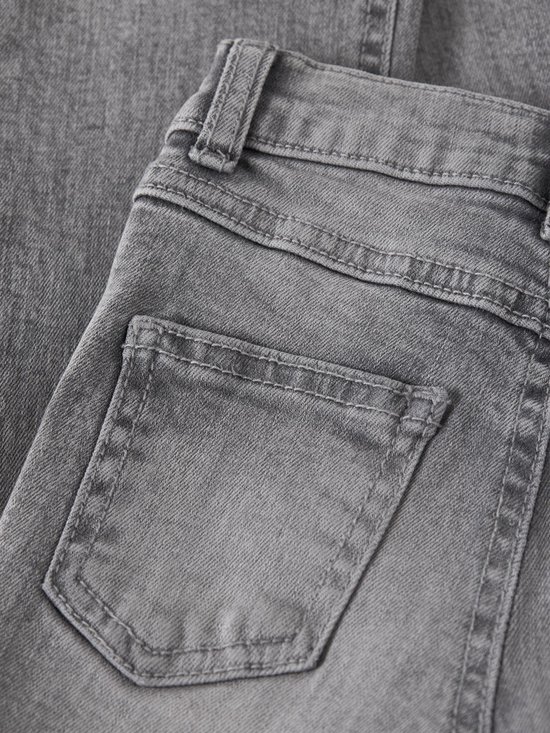 Detail van de achterzak van een grijze jeans.