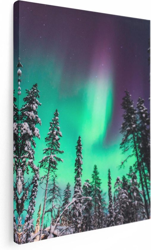 Impression sur toile de l'aurore boréale colorant le ciel en violet et vert au-dessus de pins enneigés.