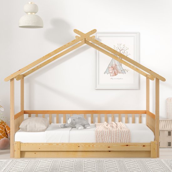 Houten huisbed met matras, kussens en een deken, met een sprookjesachtige print aan de muur.