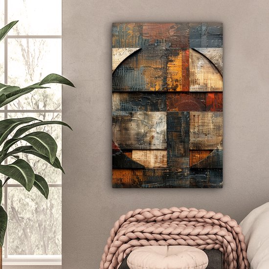 Peinture abstraite avec des motifs de bois et de carreaux dans des tons bruns, avec des éléments circulaires, accrochée à un mur près d'une fenêtre.