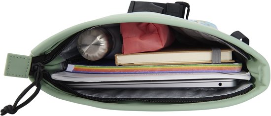 Bovenaanzicht van een open lichtgroene rugzak met inhoud: laptop, boeken, flesje en etui.
