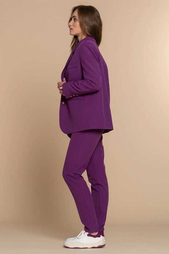 Model draagt een paarse Geisha broek en blazer, gezien vanaf de zijkant. Goudkleurige knopen op de mouw van de blazer.