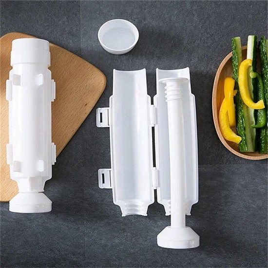 Witte sushi-maker set met losse onderdelen, een houten plank en een schaaltje met komkommer en gele paprika.