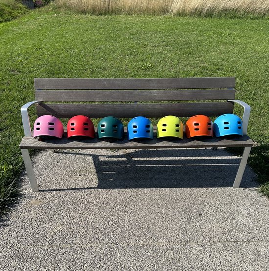 Sept casques PRO SPORT LIGHTS colorés sur un banc en bois: rose, rouge, vert, bleu, jaune, orange, bleu clair.