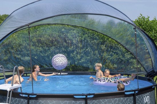 Twee kinderen spelen in een zwembad met een koepel, met een bal en zwembanden.