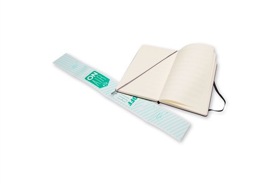 Open zwart Moleskine notitieboek met de 'ON AIR' band en een blanco pagina aan de rechterkant.
