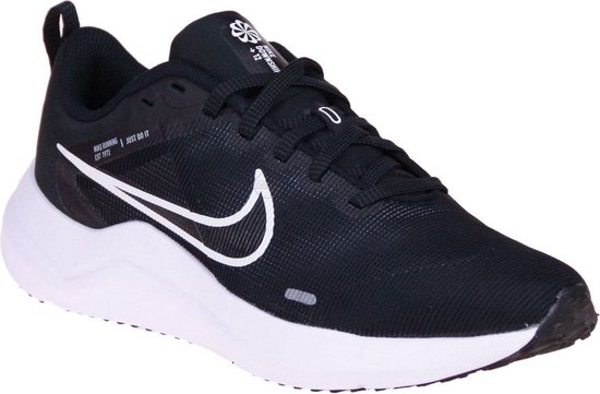 Zwarte sportschoen met witte zool, witte Nike swoosh en zwarte veters. Logo op de tong.