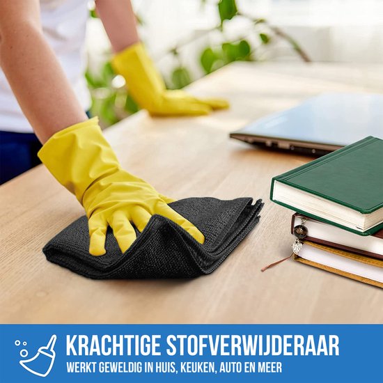 Hand met gele handschoen maakt een houten bureau schoon met een zwart microvezeldoekje.