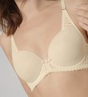 Gros plan d'un soutien-gorge à armatures beige avec bonnets moulés et texture subtile.
