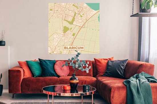 Affiche d'une carte de Blaricum style vintage, avec des routes pastel et du vert, accroché au-dessus d'un canapé orange.