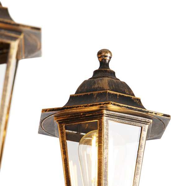 Detail van de kap van een antieke lantaarn met glazen panelen en een zichtbare gloeilamp.