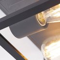 Detail van de zwarte vierkante buitenlamp met glazen wanden en gloeilamp.