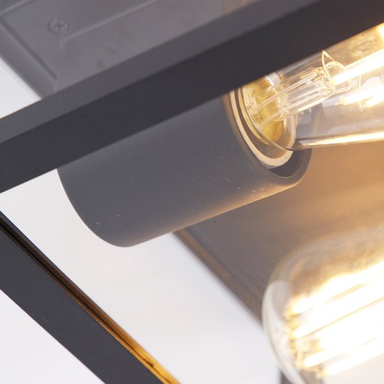 Detail van de zwarte vierkante buitenlamp met glazen wanden en gloeilamp.