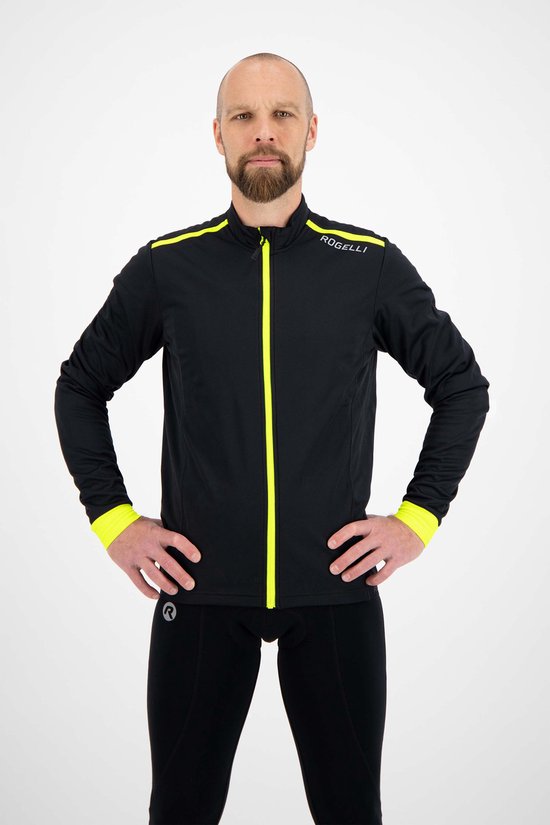 Man met baard, in zwart fietsjack met fluor gele accenten, handen in de zij.