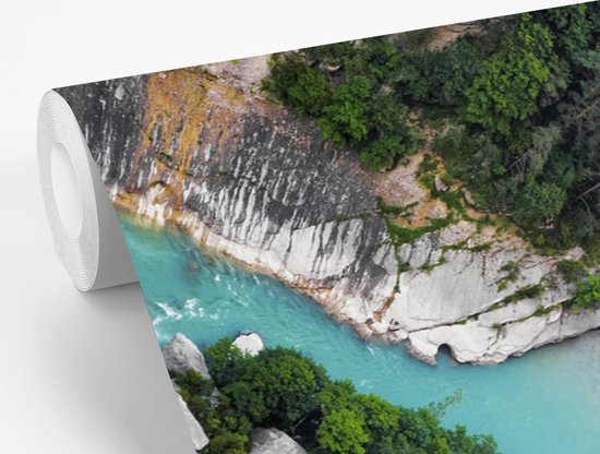 Rouleau de papier peint avec un détail des Gorges du Verdon, une rivière turquoise entre des rochers et une végétation luxuriante et verte.
