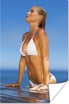 Poster Vrouw met een witte bikini die uit een zwembad komt - 120x180 cm XXL
