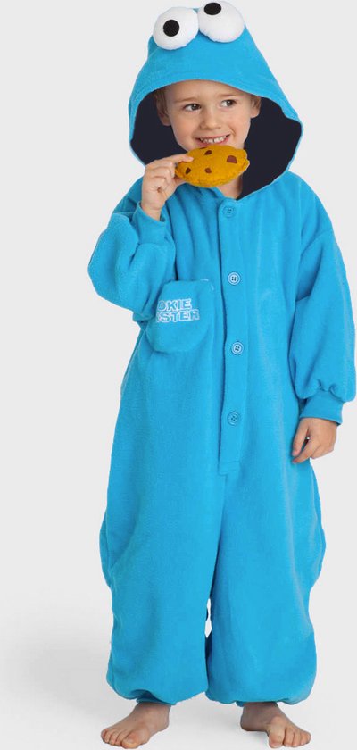Garçon en combinaison bleue Cookie Monster avec capuche, mangeant un biscuit.