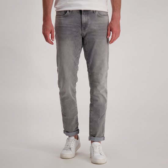 Man met grijze Cars Jeans spijkerbroek, voorkant gezien, met opgerolde broekspijpen.