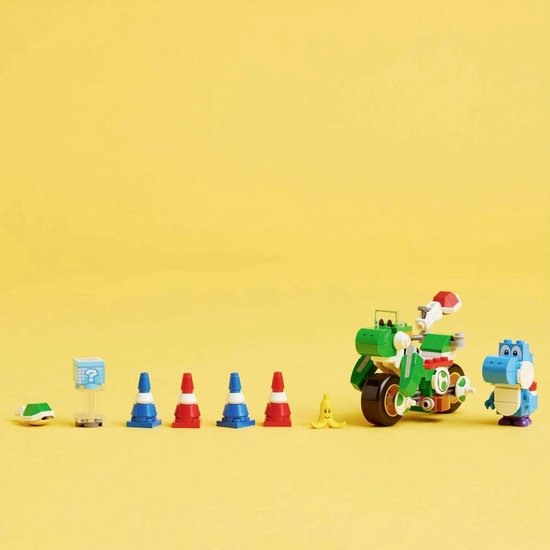 Een groene Lego-motor met een blauwe Yoshi, pionnen, een vraagteken-blok en een schild, op een gele achtergrond.