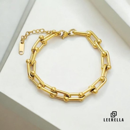 Gouden U-vormige schakelarmband met kralen, sluiting en verlengketting, op witte ondergrond.