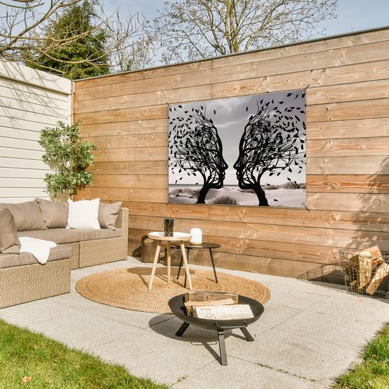 Zwart silhouet van twee bomen met gezichtsprofielen die naar elkaar toe staan, tegen een houten wand.