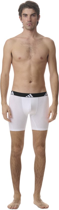 Model in wit boxerhort met zwarte band met witte Adidas logo's.