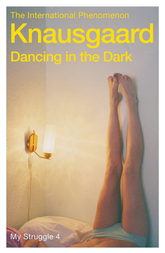 Boekomslag 'Dancing in the Dark' van Knausgaard. Vrouw ligt met benen omhoog tegen een muur bij een lamp. 'My Struggle 4'.