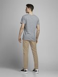 Jonge man in grijze t-shirt en beige chino broek, van achteren gezien.