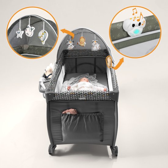 Reisbedje met slaande baby, grijze zijwanden met geometrisch patroon, mobiel met dieren en een mobiel met muziek.