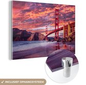 MuchoWow® Glasschilderij 120x80 cm - Schilderij acrylglas - De Golden gate bridge met een mooie paarse lucht - Foto op glas - Schilderijen
