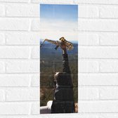Muursticker - Man met Trompet aan de Rand van Cliff met Uitzicht - 20x60 cm Foto op Muursticker