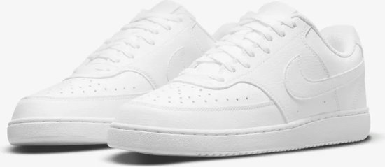 Een paar witte Nike Court Vision sneakers, schuin van voren gezien, met vetersluiting.