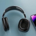Zwarte AirPods Max met een doorzichtige hoes, naast een smartphone.