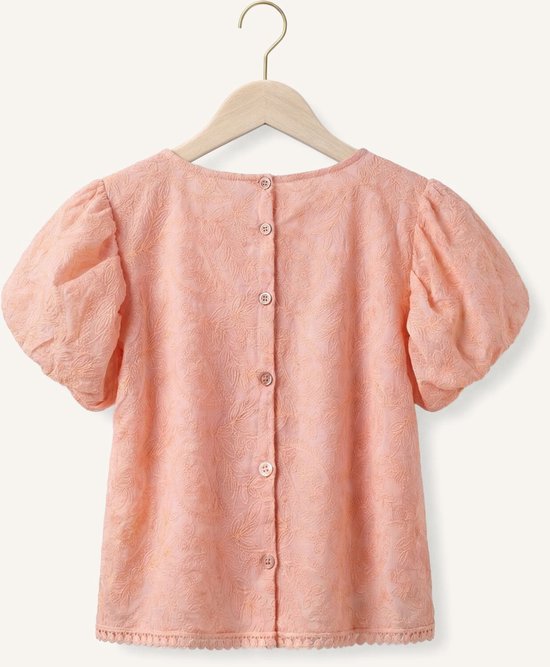 Achterkant van een perzikkleurige blouse met kanten textuur, korte pofmouwen en knoopsluiting.