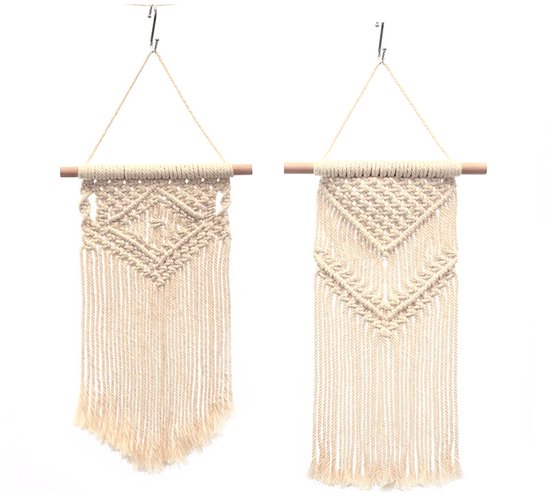 Twee off-white macramé wandkleden, opgehangen aan houten stokken met gedetailleerde knopen en lange franjes.