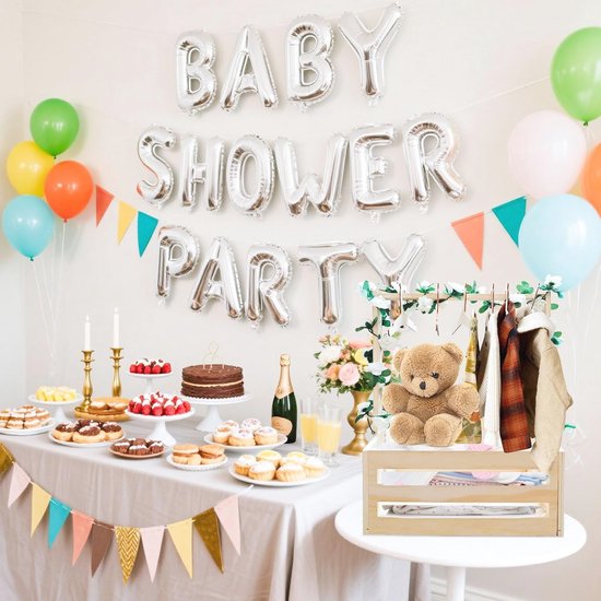 Houten babymand met kleding en teddybeer op een tafel bij een 'Baby Shower Party'.