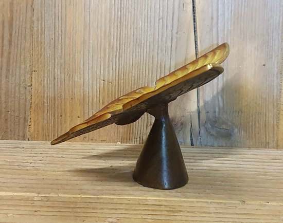 Décoration de papillon en bronze sur un pied sombre et effilé, avec une finition dorée patinée.