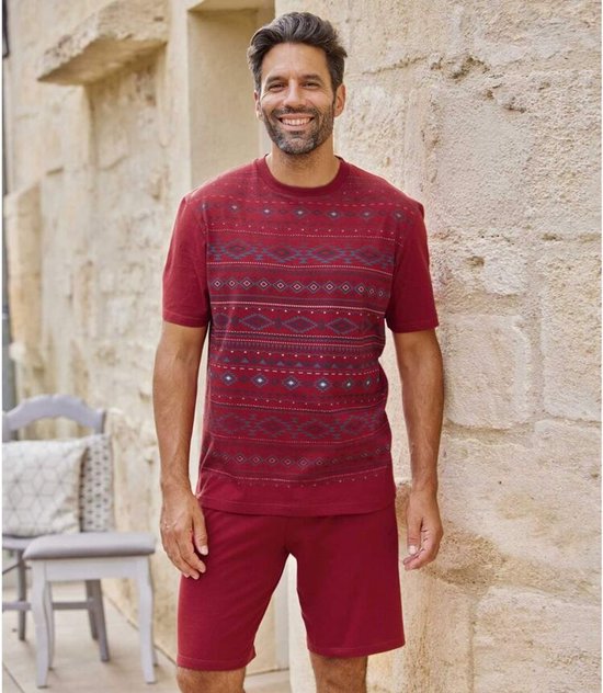 Man met een pyjamaset van ATLAS FOR MEN. De set bestaat uit een bordeauxrood T-shirt met micromotief en een bijpassende korte broek.