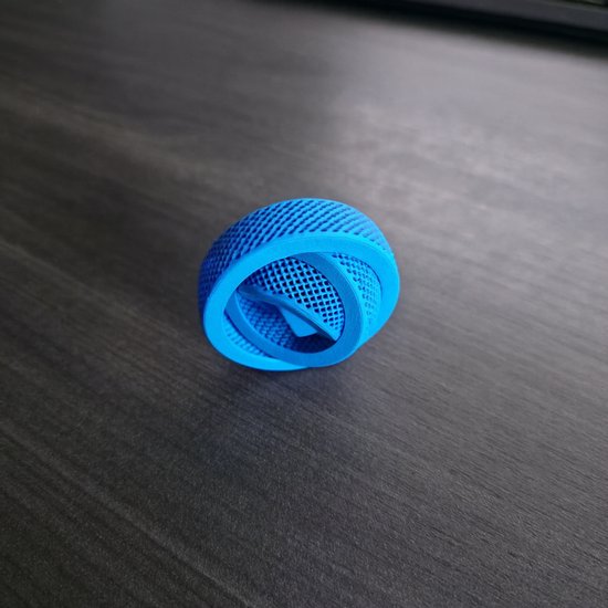 Cyaan gekleurde gyrospeelgoed met een open, rasterachtig ontwerp, liggend op een houten ondergrond.