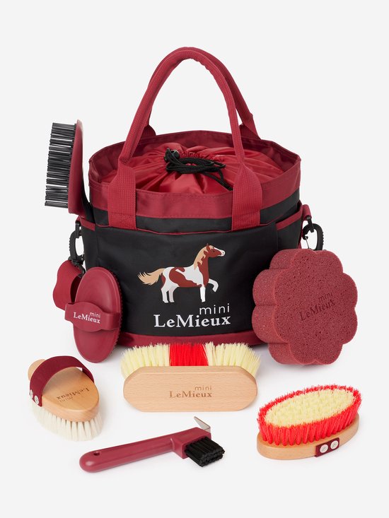 Een gevulde rode Mini LeMieux poetsstas met paardendessin en accessoires.
