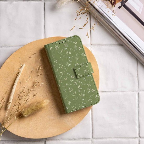Groen telefoonhoesje met bladerpatroon op een houten plank.