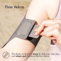 Een hand sluit de grijze sportarmband om een arm met behulp van klittenband. Tekst 'Firm Velcro' staat bovenaan.