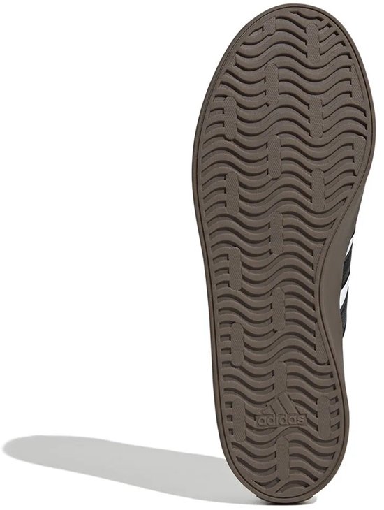 Onderkant van een bruine sneakerzool met Adidas logo en golvend profiel.