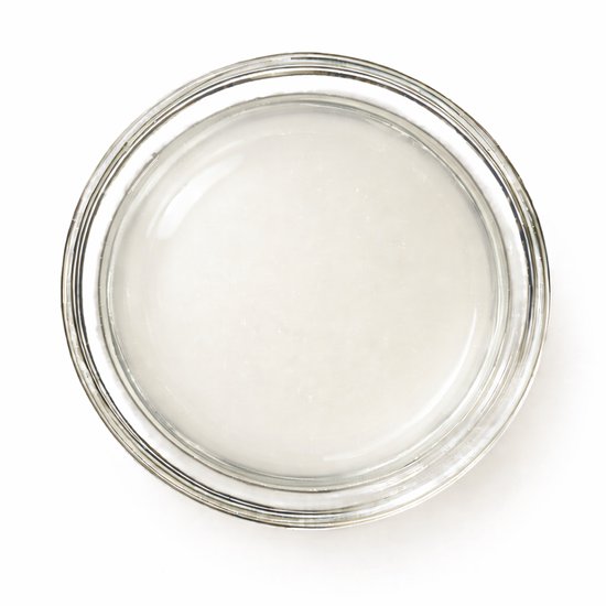 Glazen potje met emoe olie, een lichte, doorschijnende vloeistof.